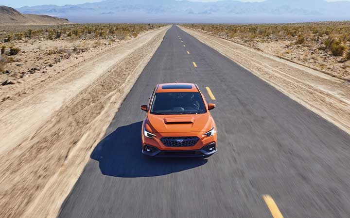 The 2022 Subaru WRX driving down a highway.